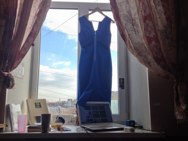 Платье на вешалке в 8-ми метровой коммунальной комнате на Васильевском острове в Питере.