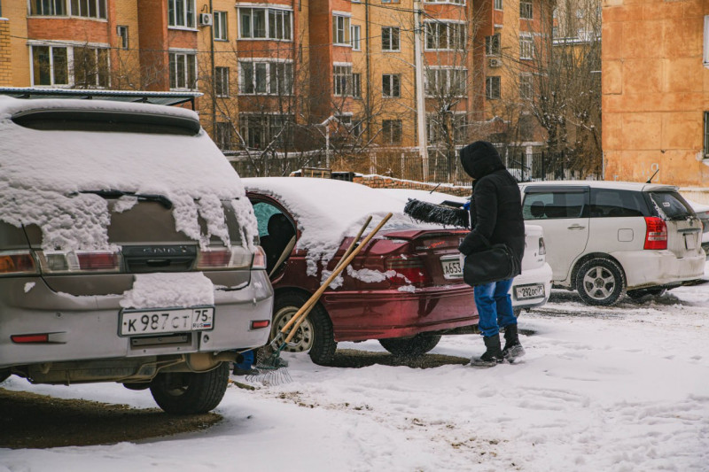 Читинец чистит машину от снега