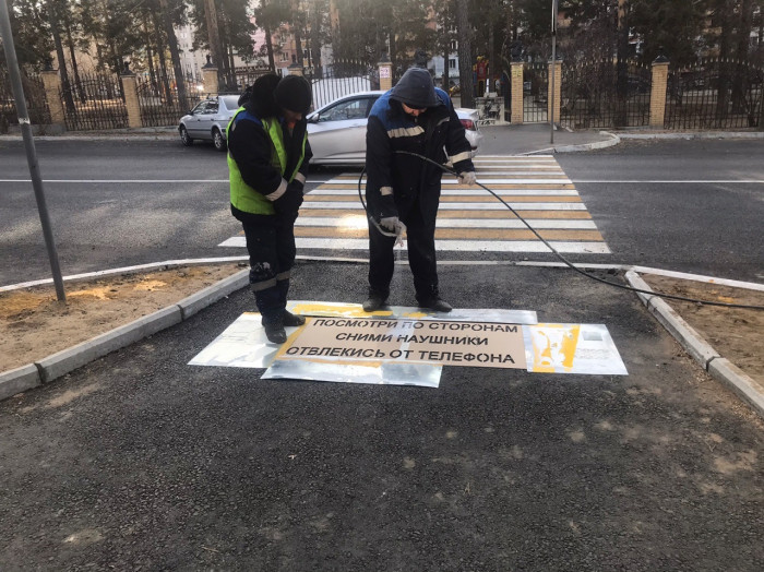 Дорожники наносят предупреждающие надписи возле пешеходных переходов в Чите