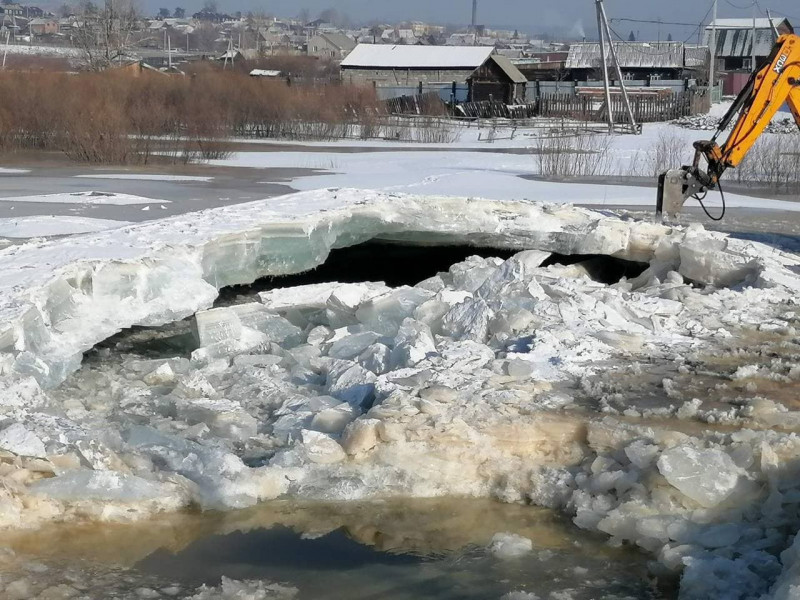 Рабочие разбили ледяной панцирь для отвода воды в Песчанке