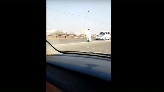 Закутанный в простыню мужчина перекрывает дорогу машинам в Чите
